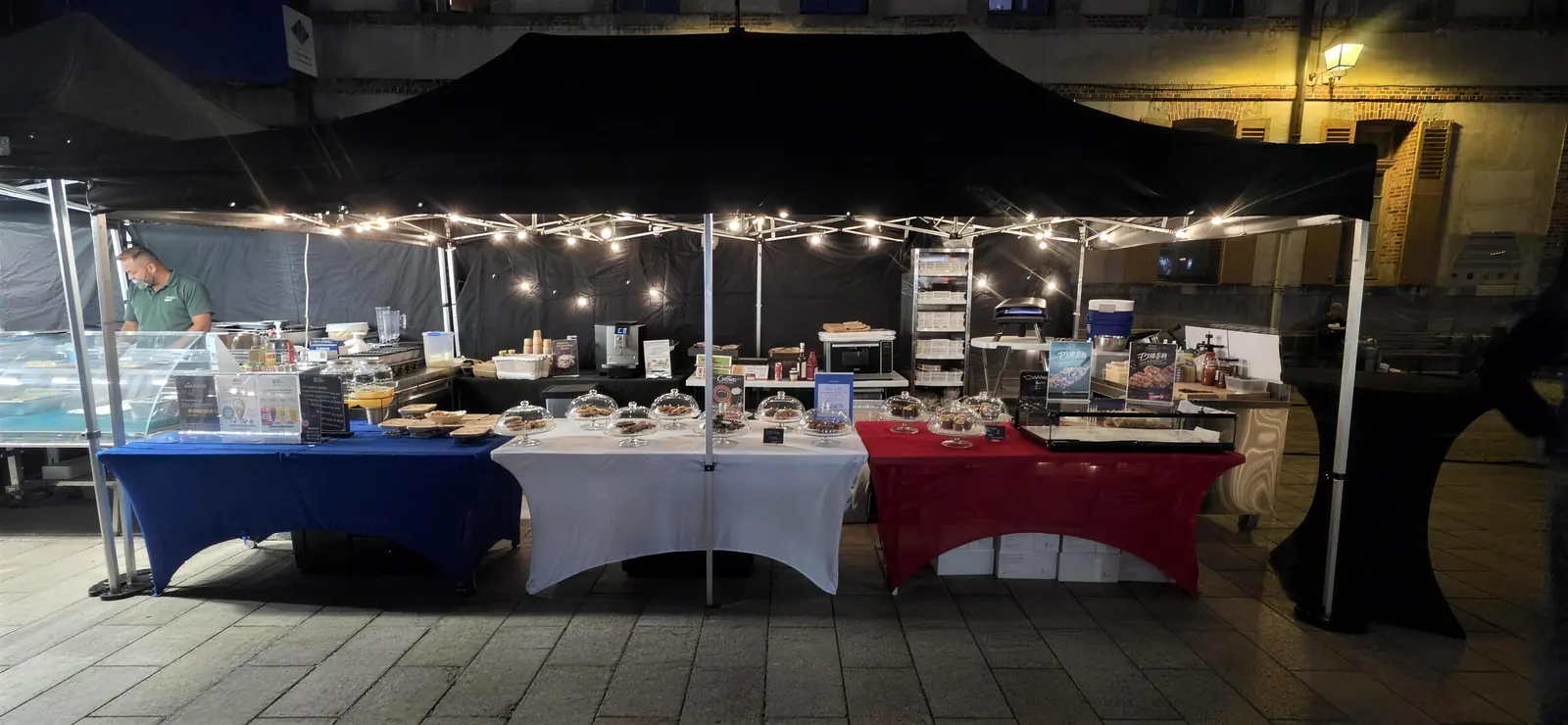 Le stand sous guirlandes lumineuses, vu de face, à la tombée de la nuit